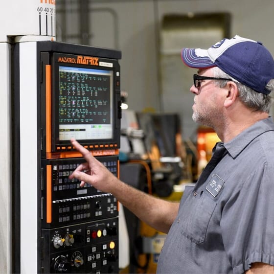Machinist operating CNC control panel