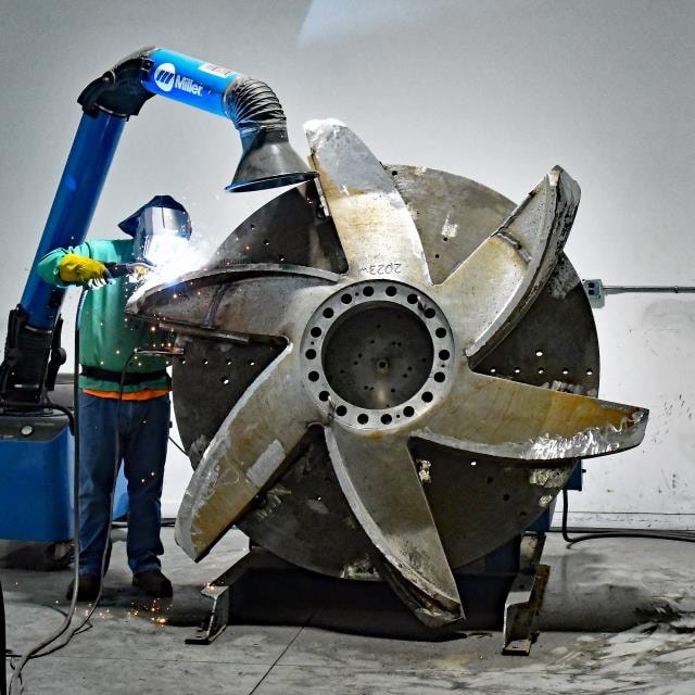 Welder working on large industrial fan impeller